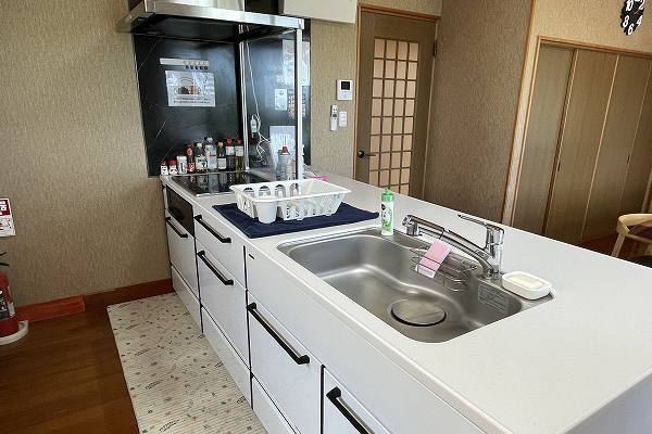 清潔感ある白の配色のオープンキッチンはIHクッキングヒーター仕様